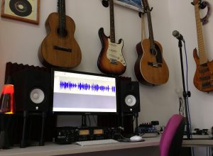 A studio with acoustic and electric guitars on the wall